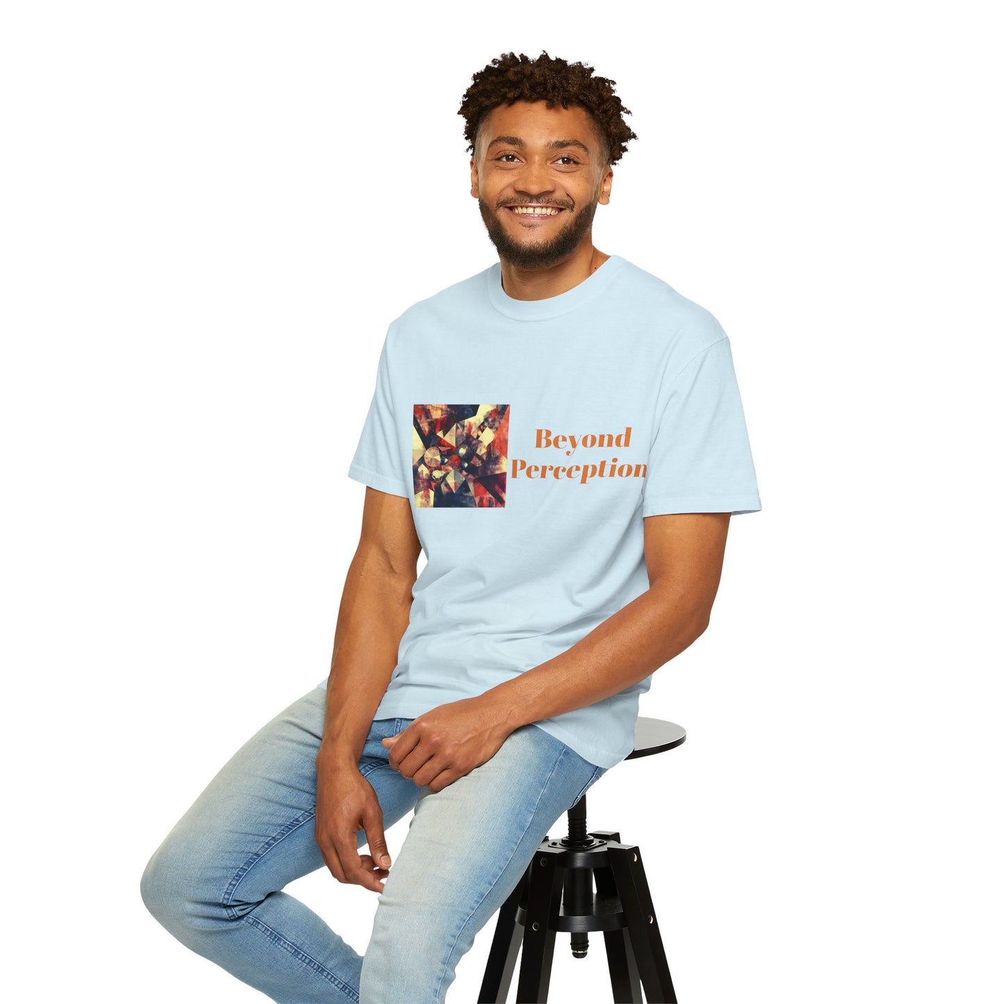 A man sitting on a chair while wearing a chambray T-shirt featuring an enchanting abstract design and refined typography.