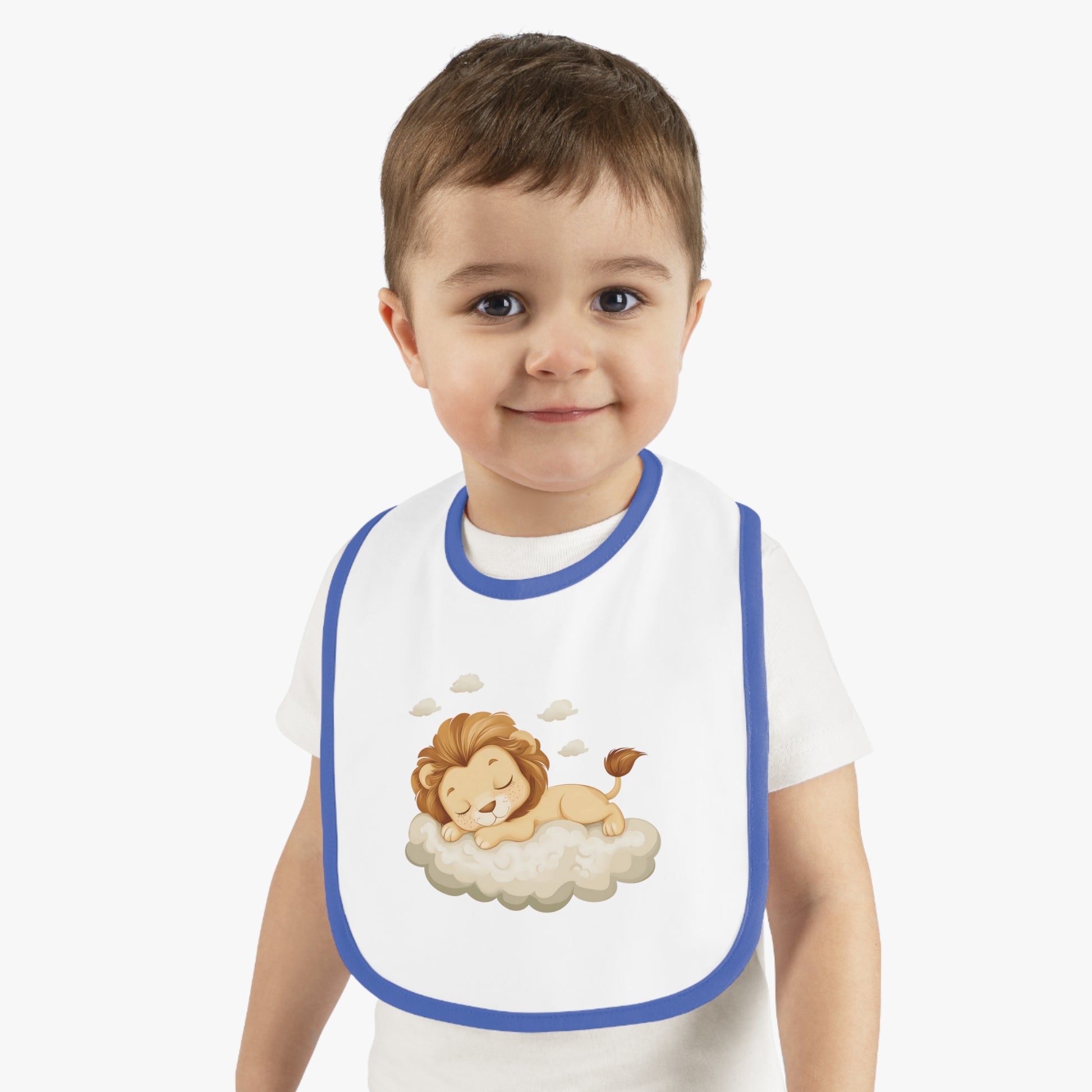 A baby boy wearing an adorable bib with a royal blue-colored trim and a white base, featuring a design of a cute lion peacefully sleeping on a fluffy cloud.