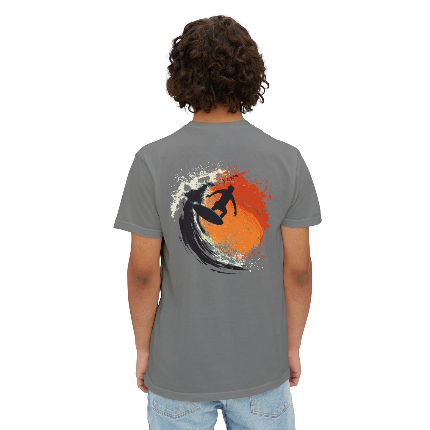 A man wearing a grey T-shirt featuring a design of a surfboard, waves, and a surfer on the back.