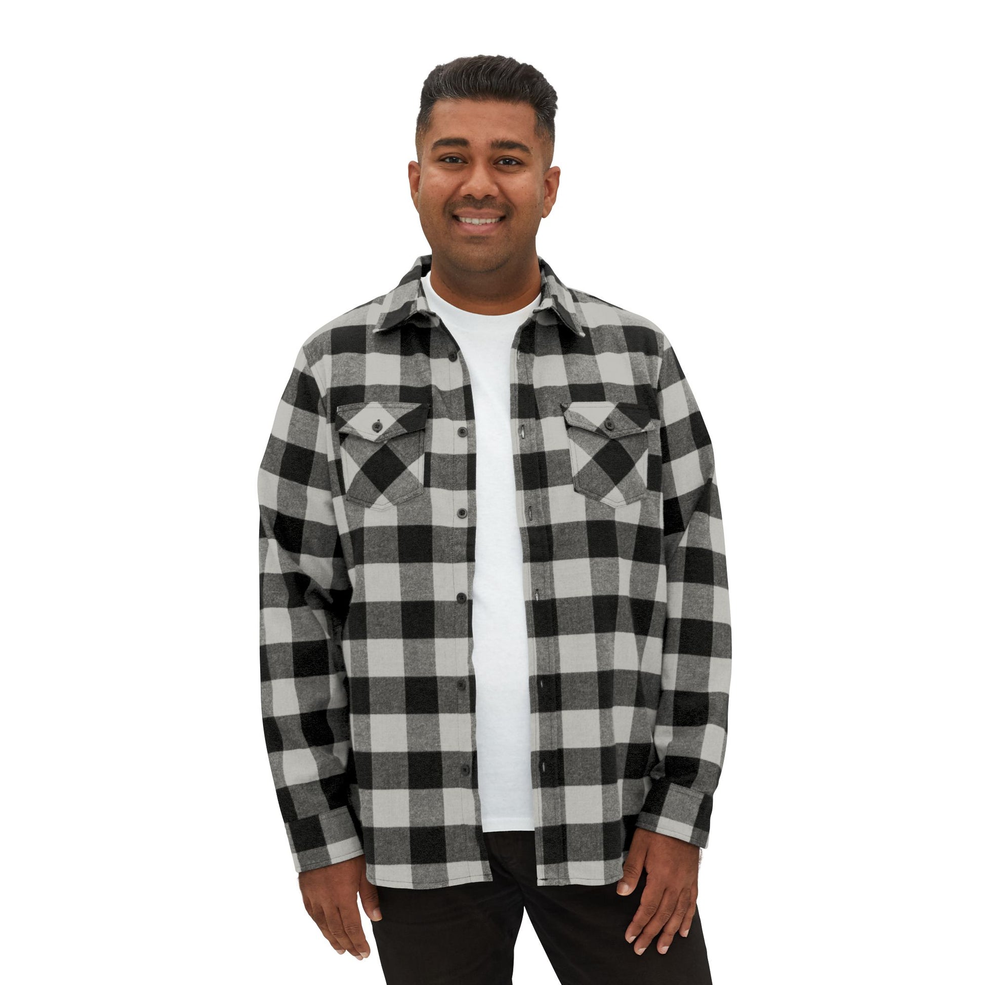 A man standing in a classic black-and-white buffalo plaid flannel shirt, exuding a rugged yet stylish look.