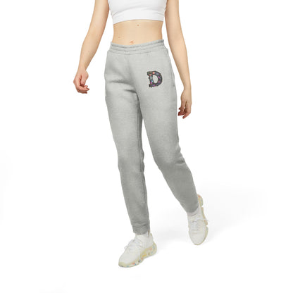 A slim woman wearing Grey Heather joggers featuring a bold "D" design on the front with a retro-futuristic and holographic vibe.