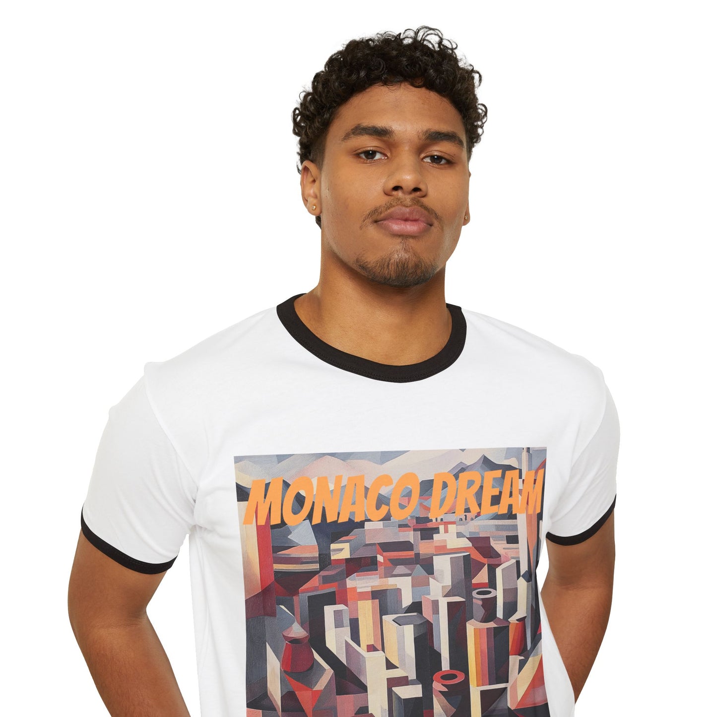 A man wearing a white/black T-shirt featuring the "Monaco Dream" print, showcasing a dynamic geometric cityscape in retro-futuristic colors.