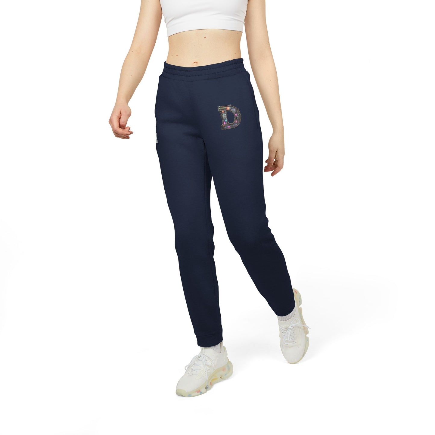 A slim woman wearing Collegiate Navy joggers featuring a bold "D" design on the front with a retro-futuristic and holographic vibe.