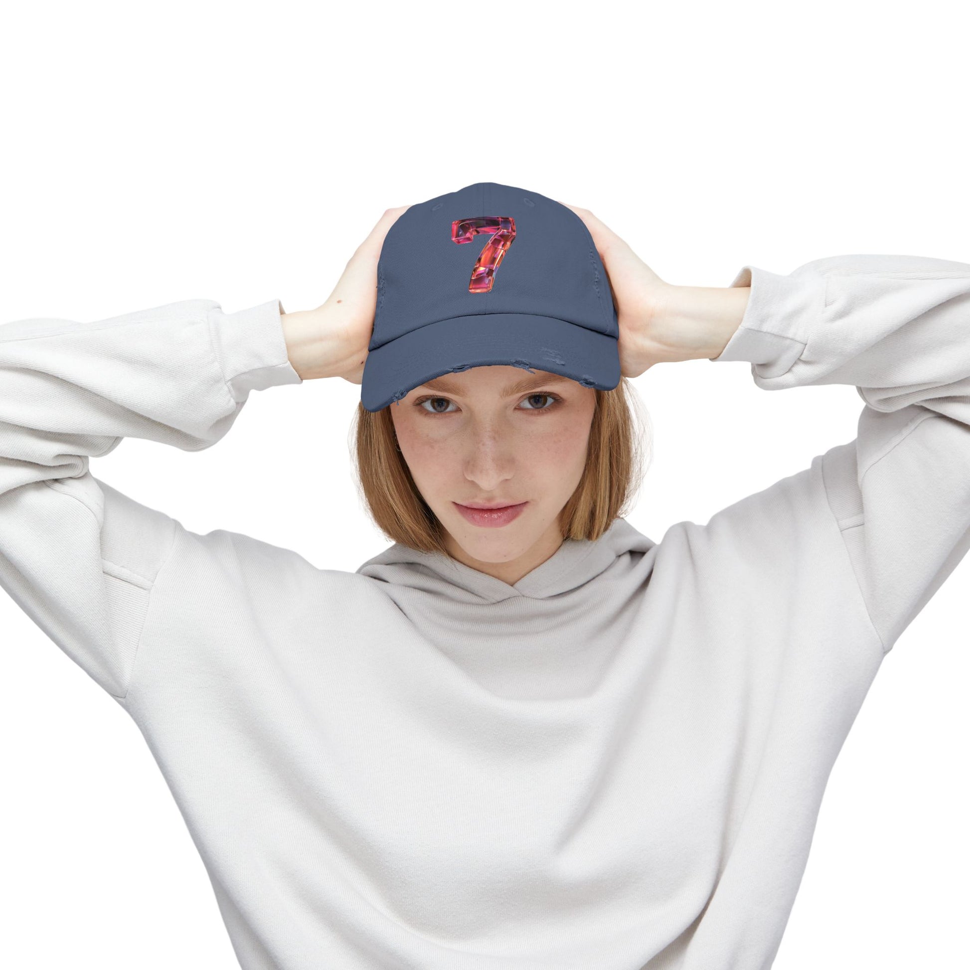 A woman facing forward while wearing a distressed Scotland Blue cap featuring a unique and modern design with a 3D image of the number "7" in a transparent glass style.
