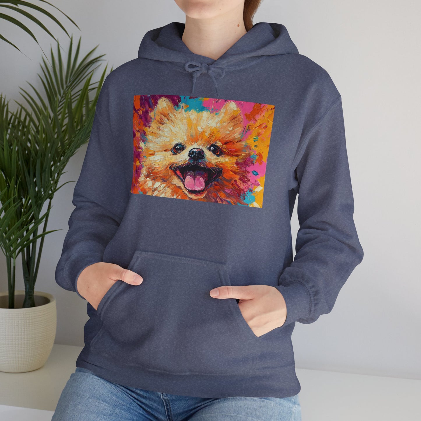 A woman standing and facing directly left in a Heather Navy hoodie featuring vibrant Pomeranian dog artwork in an acrylic style.