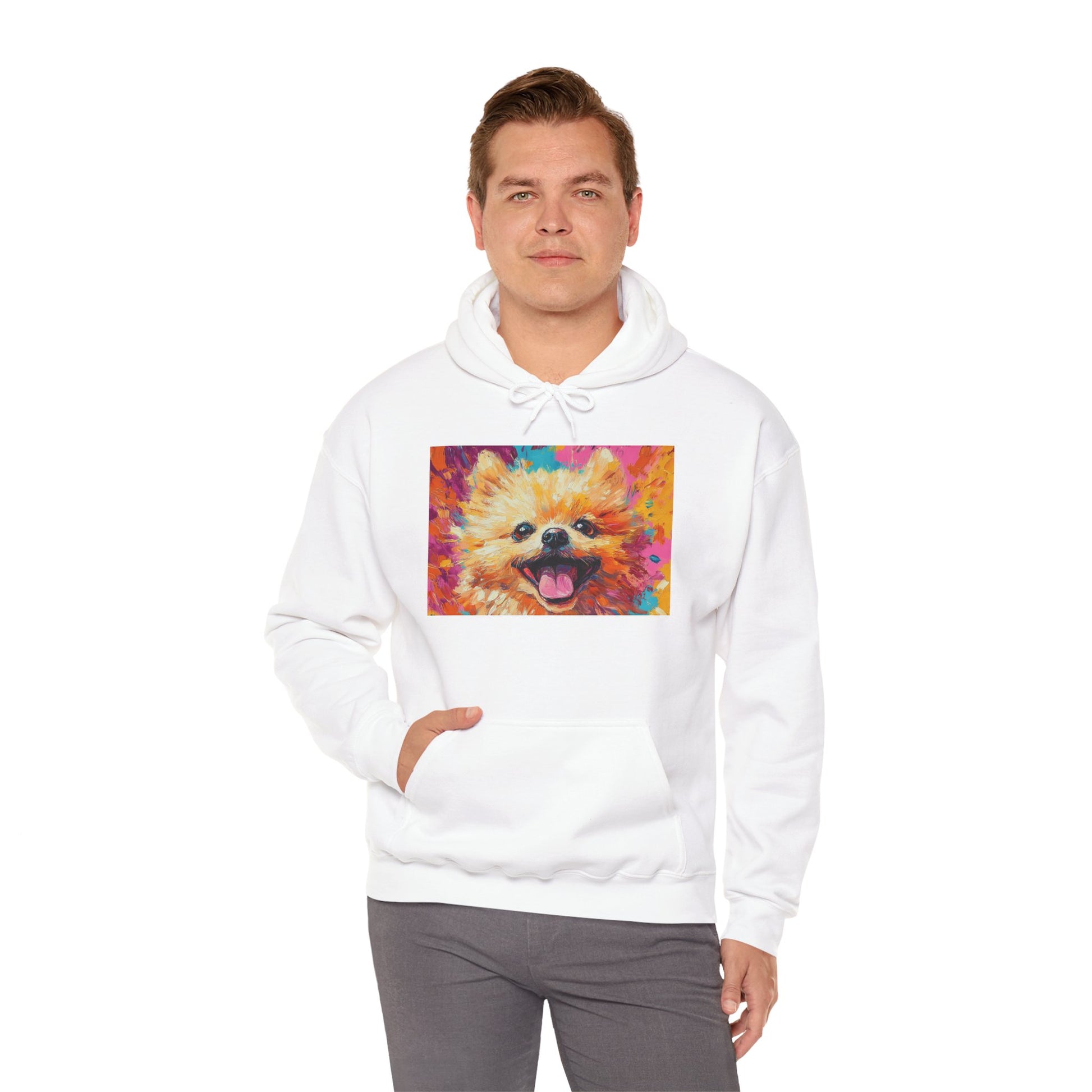 A man wearing a White hoodie with a vivid acrylic-style artwork of a Pomeranian dog, with one hand in his pocket.
