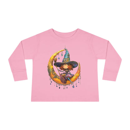 A Pink long-sleeve T-shirt featuring a whimsical design of a small witch sitting on a large moon adorned with scattered crystals.