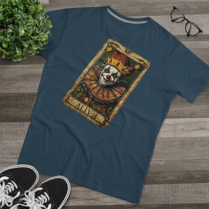 A Denim T-shirt with a Tarot card design featuring a clown against a dark grunge-style background, laid on the floor with glasses and shoes.