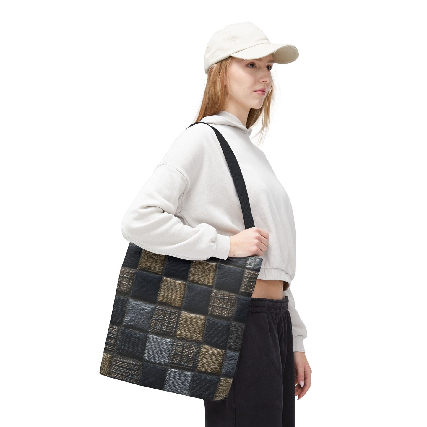 Young woman wearing a cap and holding a black, grey, and olive green checkerboard tote bag with faux leather texture—trendy everyday accessory for urban style.