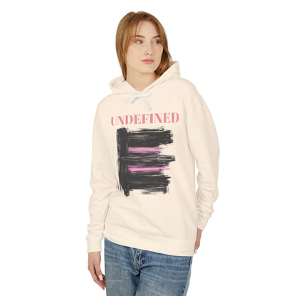 A woman wearing an ivory hoodie featuring bold black brushstrokes with subtle pink accents, enhancing its modern and artistic vibe.