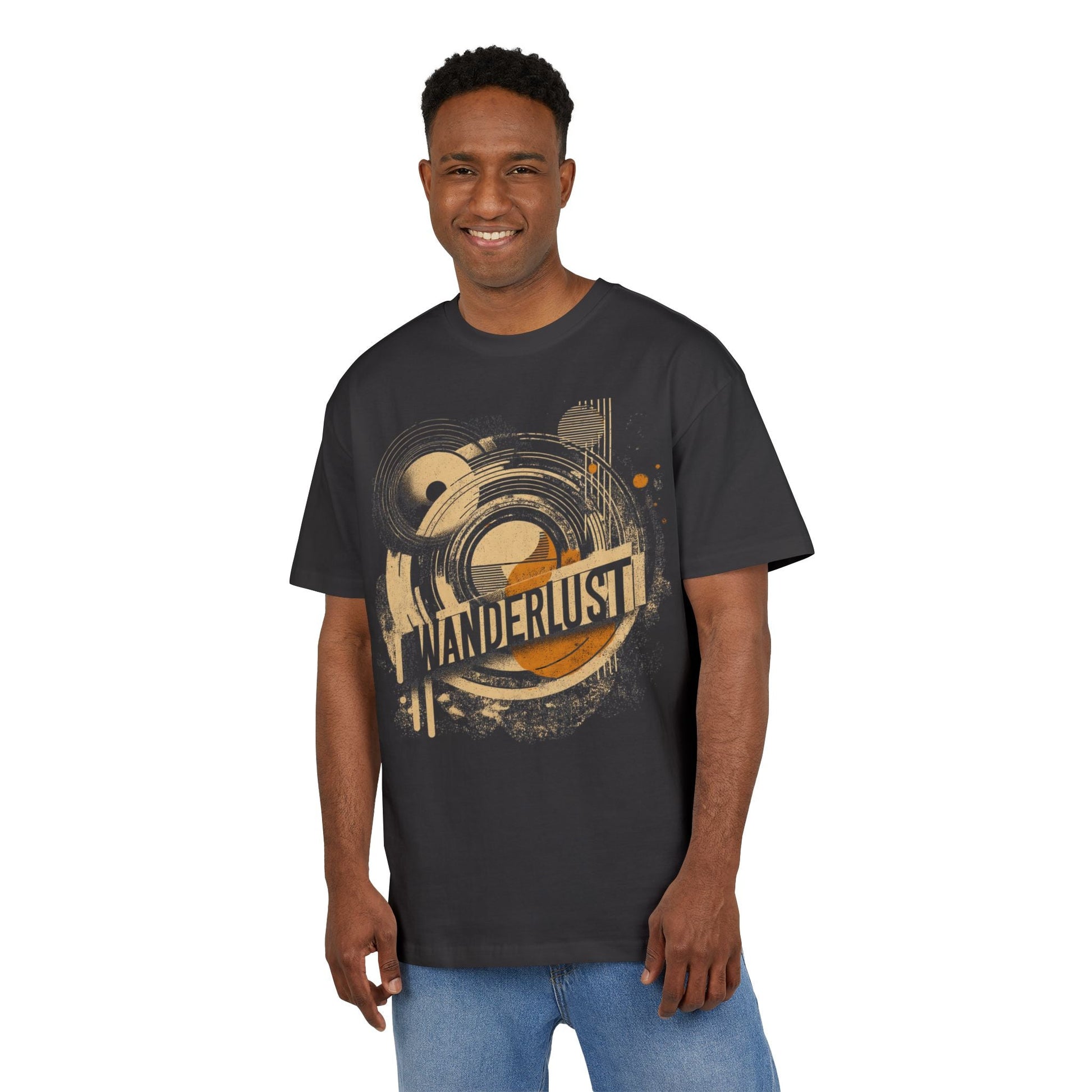 Man wearing black men’s T-shirt with “WANDERLUST” graphic featuring orange and beige geometric shapes and concentric circles—retro travel-inspired streetwear look.