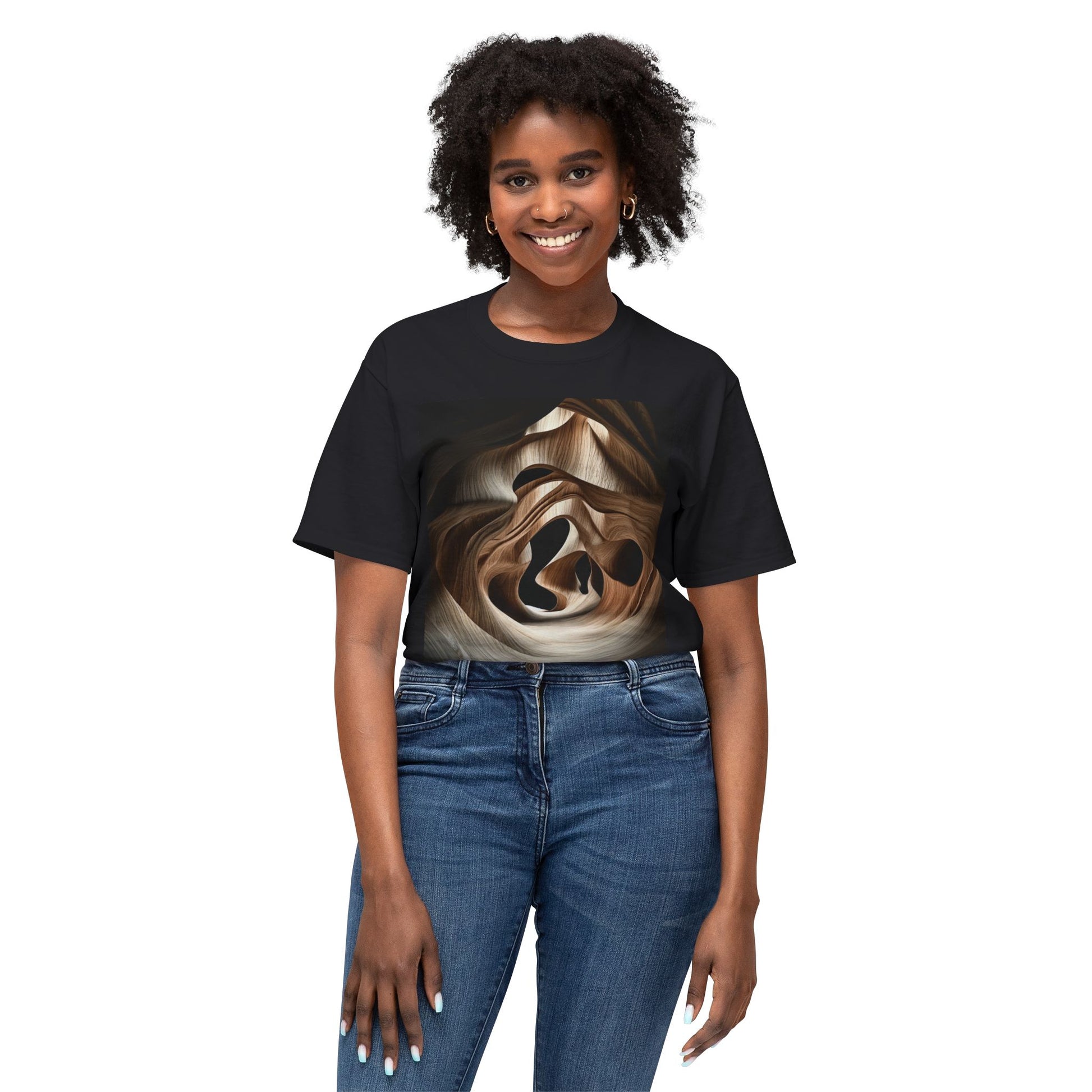 A curly-haired woman wearing a Black-colored T-shirt with an abstract, wave-like wood grain pattern.
